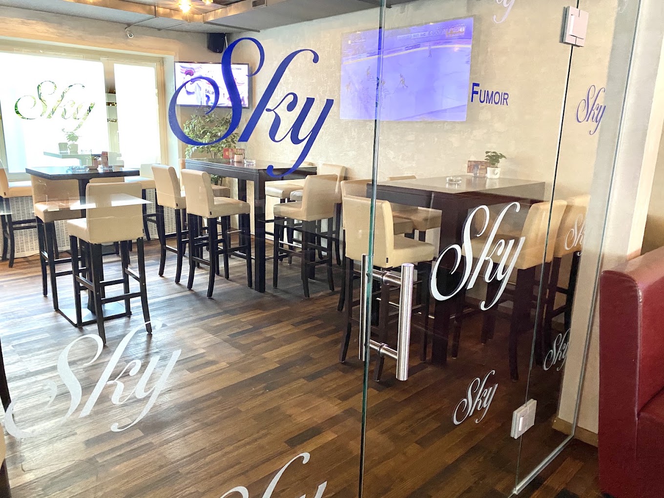 Sitzbereich der Sky Lounge Bar mit Sky Schriftzug auf Glas